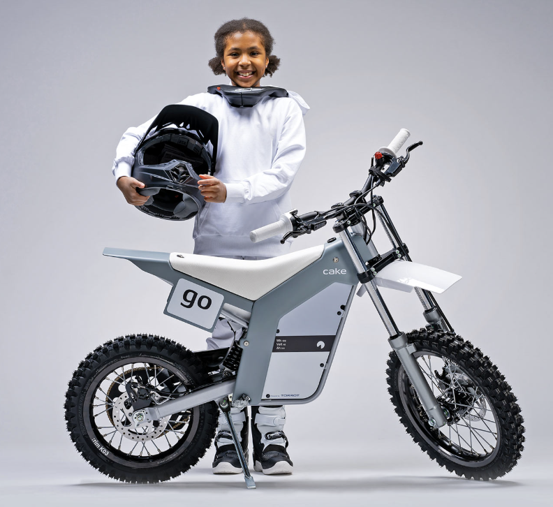 Young rider standing with a CAKE motorcycle